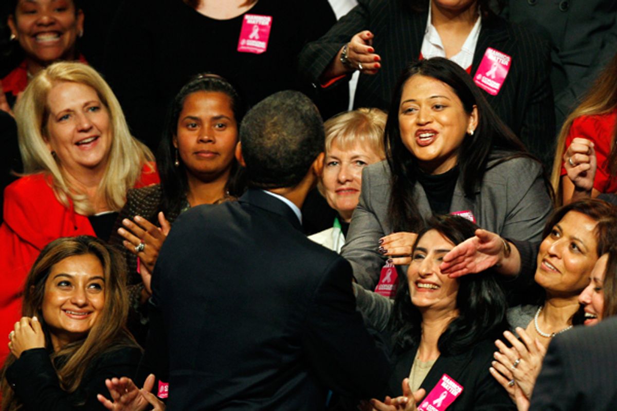 President Obama greets women onstage in November 2009.    (AP/Mel Evans)