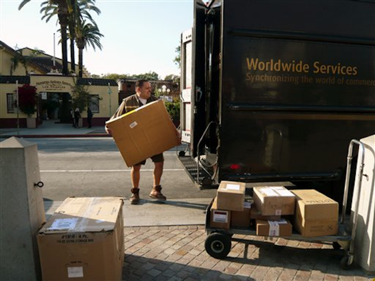 In this March 6, 2012 photo, a UPS worker loads packages in Los Angeles    (AP Photo/Damian Dovarganes)
