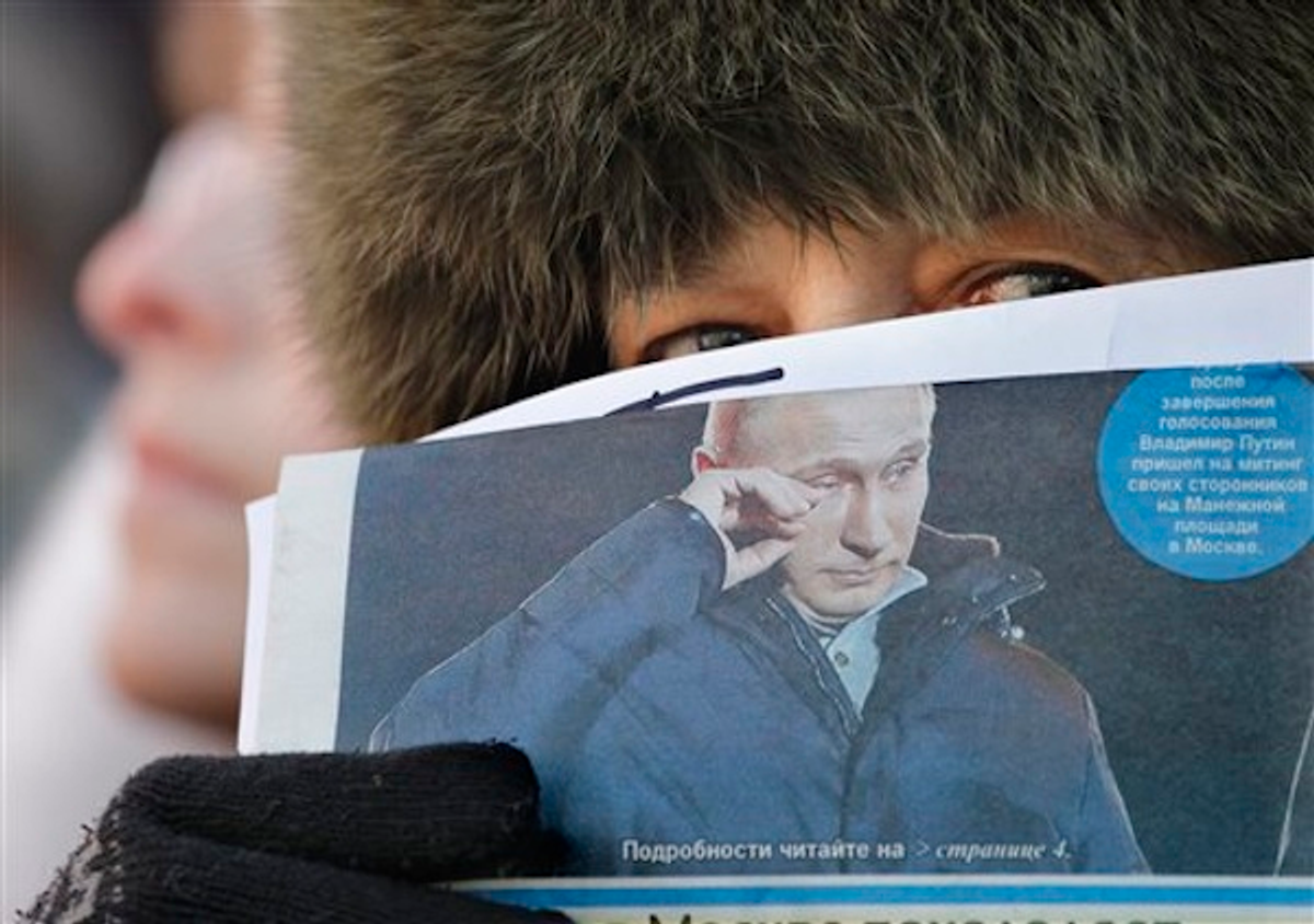 A protester holds a newspaper showing president-elect Vladmir Putin during an opposition rally in Moscow, Russia, Saturday, March 10, 2012                    (AP Photo/Ivan Sekretarev)
