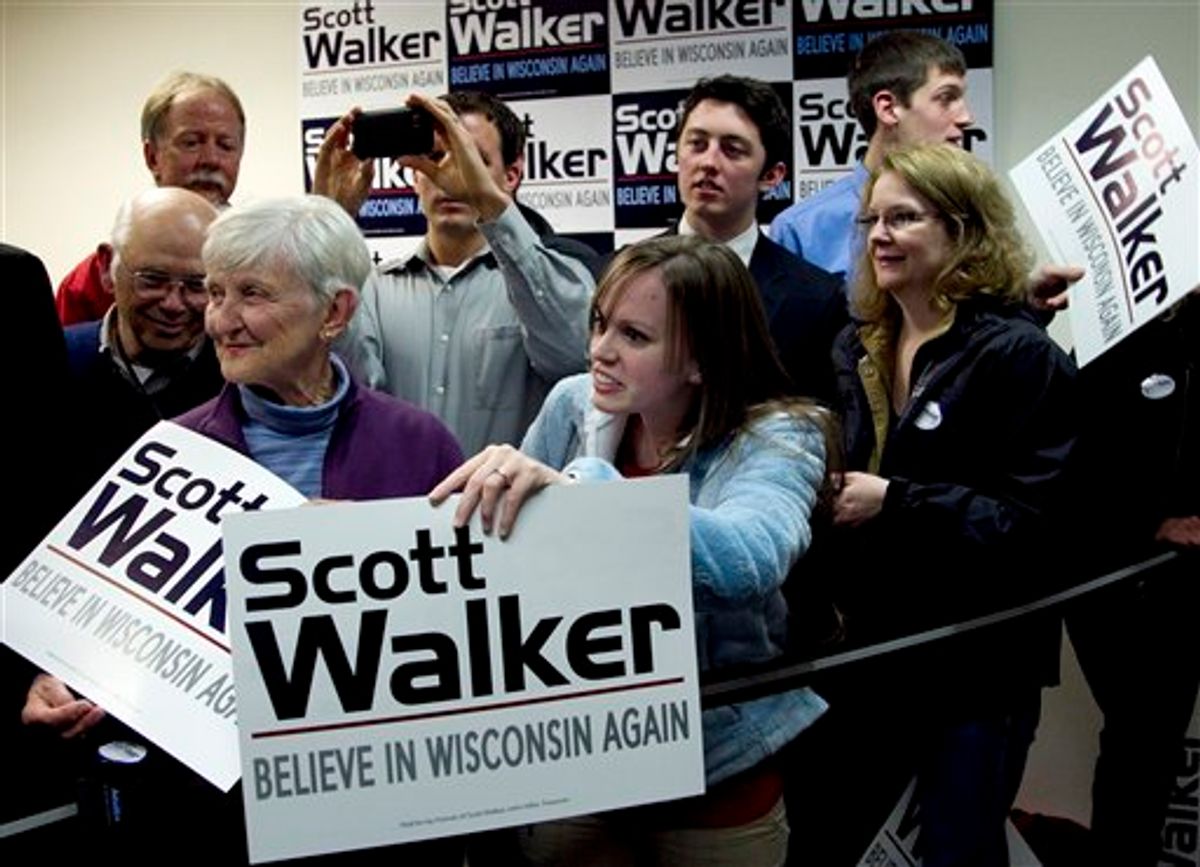 Supporters of Wisconsin Republican Gov. Scott Walker display placards during a visit by Republican presidential candidate, former Massachusetts Gov. Mitt Romney, not shown, during a campaign stop in Fitchburg, Wis., Saturday, March 31, 2012.  The phone bank is used in support of Walker who is facing a recall election in June 2012. (AP Photo/Steven Senne)   (AP)