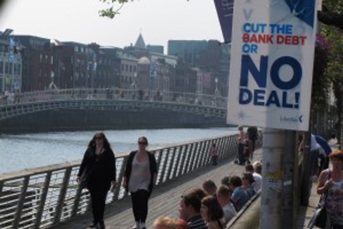  Dubliners bask in the sunshine on the River Liffey on Friday, May 25, 2012, as an anti-EU poster advises voters to reject the European Union's fiscal treaty in Dublin, Ireland.         (AP Photo/Shawn Pogatchnik)