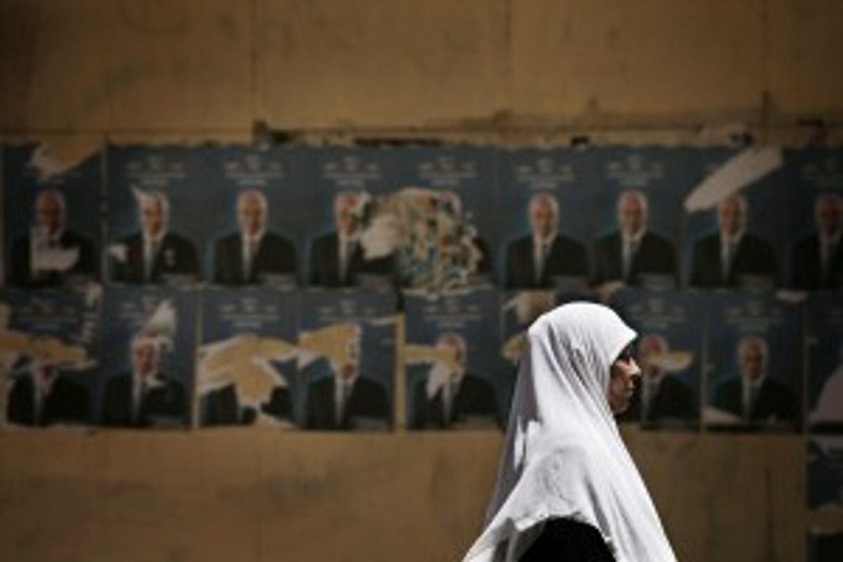  An Egyptian woman walks past defaced posters of Egyptian presidential candidate Ahmed Shafiq in Cairo, Egypt, Wednesday, May 16, 2012.            (AP Photo/Manu Brabo)