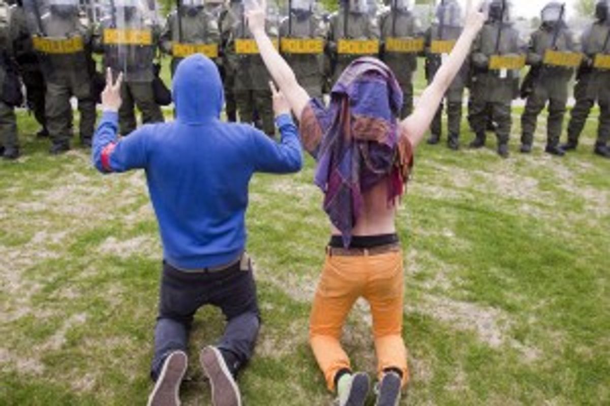Students protesting against tuition hikes kneel in front of a line of Quebec Provincial Police at the Lionel Groulx college Tuesday, May 15, 2012 in Ste. Therese, Quebec, Canada.     (AP Photo)