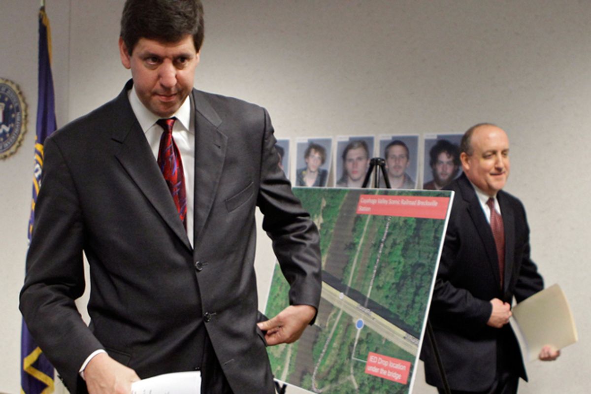 U.S. Attorney Steven Dettelbach, left, and FBI special agent in charge Stephen Anthony walk past a map showing the location of a bridge on Ohio Rt. 82. Five men, pictured on the wall behind the map, have been arrested for conspiring to blow up the bridge.      (AP/Mark Duncan)