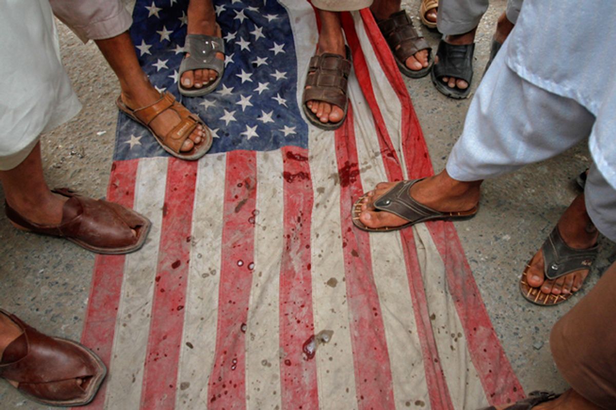 Pakistani men step on a U.S flag during an anti-American rally in Peshawar on April 13.         (Reuters/Fayaz Aziz)