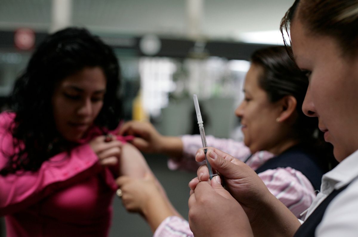 Health workers prepare a passenger for a vaccination against measles at the Benito Juarez international airport in Mexico City.    (Reuters)