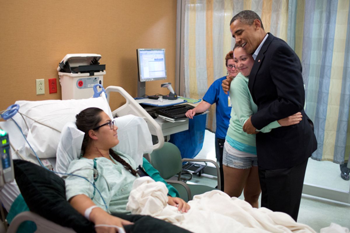 President Obama hugs Stephanie Davies, who helped keep her friend, Allie Young, left, alive after she was shot during the movie theater shootings in Aurora, Colo.        (The White House/Pete Souza)