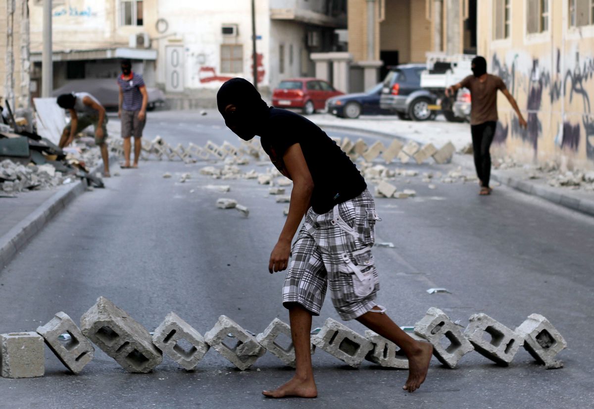 Masked Bahraini youths set up roadblocks in Bilad al-Qadeem, Bahrain.     (AP/Hasan Jamali)