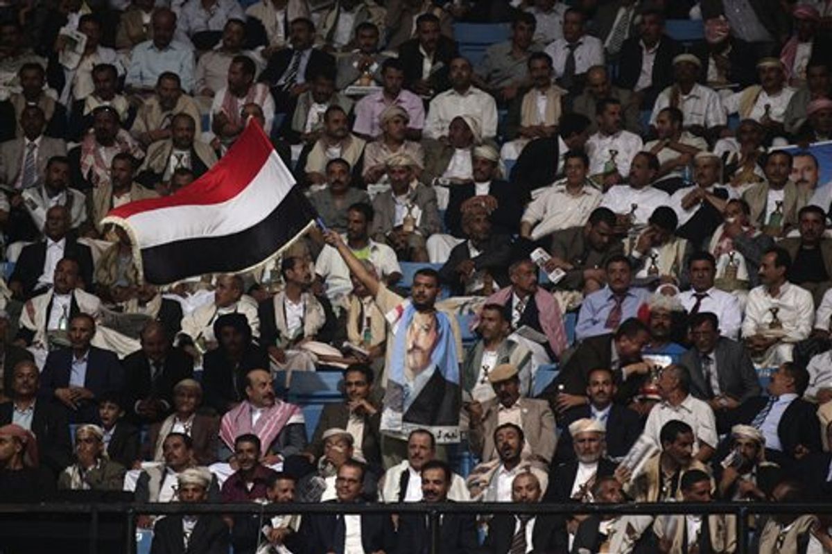 A supporter of former Yemen's President Ali Abdullah Saleh, center, waves Yemen's national flag during a ceremony marking the 30th anniversary of Saleh's General People's Congress party (GPC) establishment in Sanaa, Yemen, Monday, Sept. 3, 2012. (AP Photo/Hani Mohammed)     