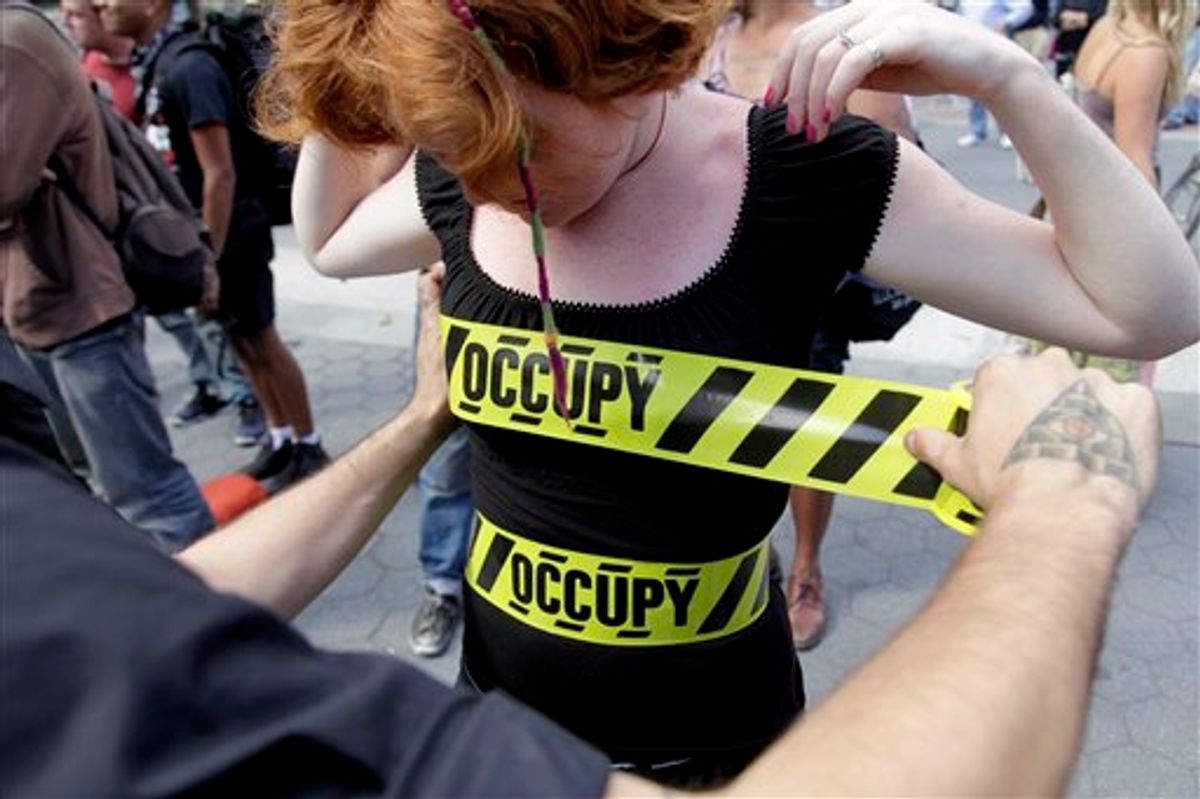 "Occupy" security-style tape is stuck to Laura Nagy during an Occupy Wall Street anniversary concert in Foley Square in New York on Sunday, Sept. 16, 2012. (AP/Seth Wenig)    