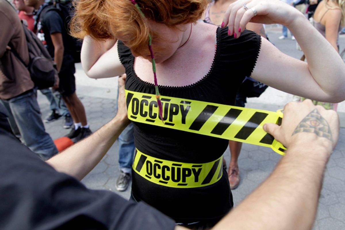 "Occupy" security-style tape is stuck to Laura Nagy during an Occupy Wall Street anniversary concert in Foley Square in New York on Sunday, Sept. 16, 2012. The Occupy Wall Street movement will mark its first anniversary on Monday.              (AP/Seth Wenig)