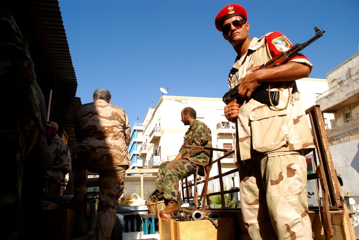 Libyan security forces stand guard as people turn in weapons in Benghazi, Libya.     (AP/Ibrahim Alaguri)