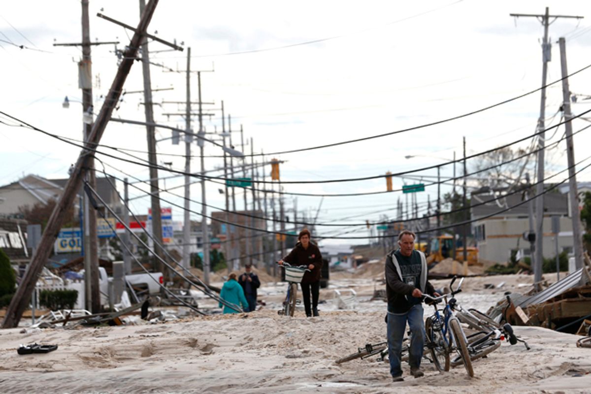 People walk through sand that washed up from the beach and onto Route 35 during superstorm Sandy, Wednesday, Oct. 31, 2012, in Lavallette, N.J.      (AP/Julio Cortez)