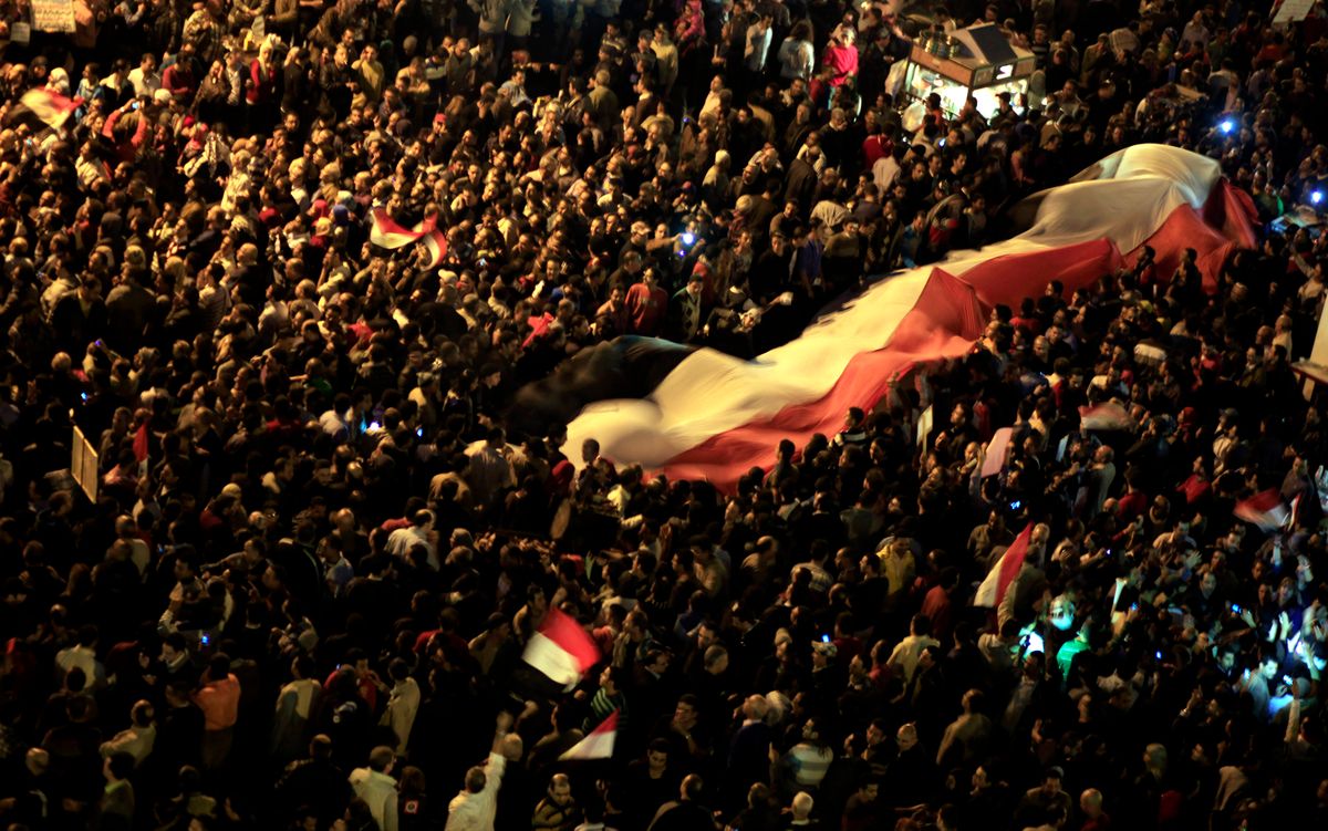 Egyptian protesters unfurl a large national flag at an opposition rally in Tahrir Square in Cairo, Egypt.        (AP/Khalil Hamra)