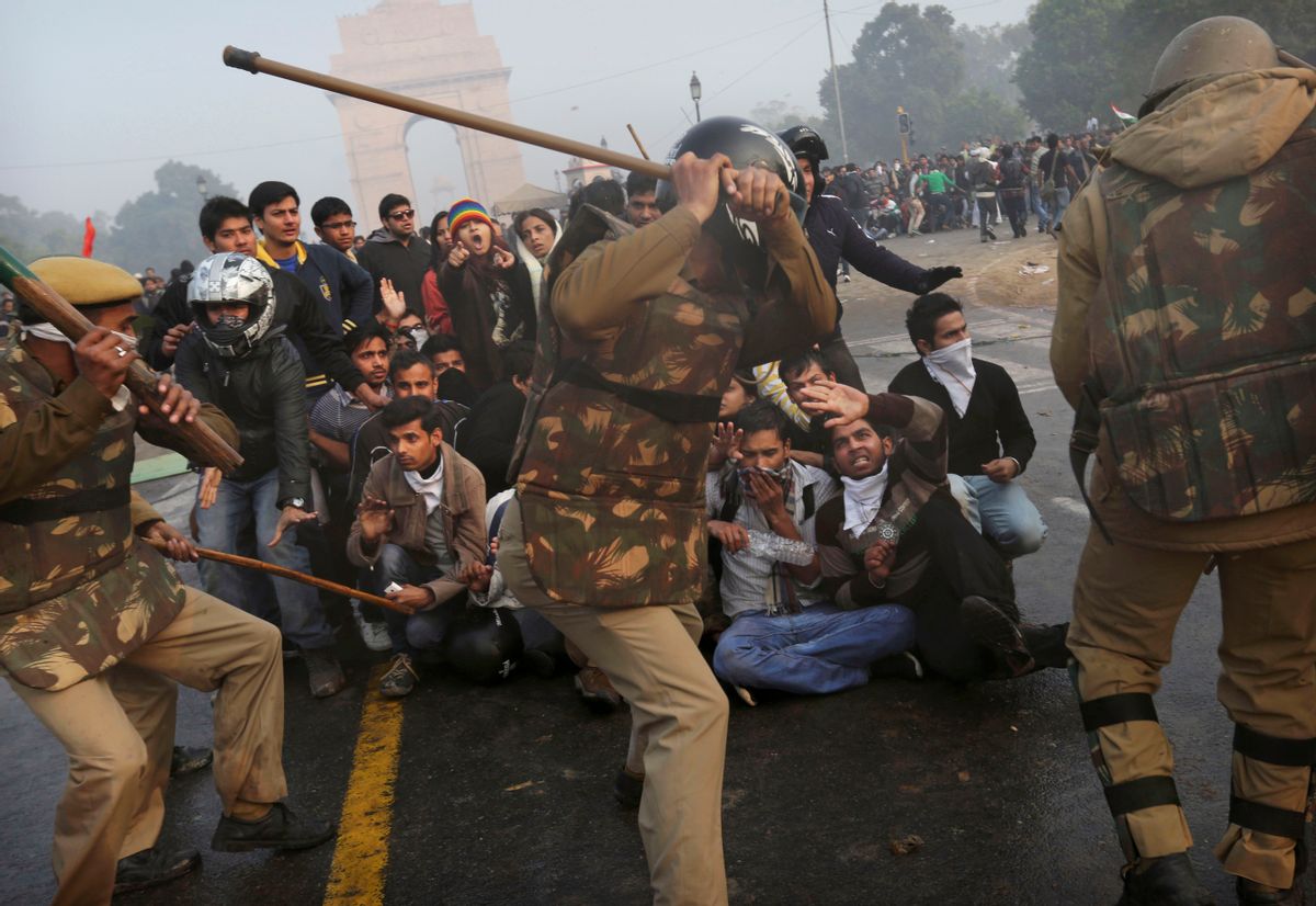 Protesters shield themselves as Indian police beat them with sticks during a violent demonstration near the India Gate against a gang rape and brutal beating of a 23-year-old student on a bus last week, in New Delhi, India.               (AP/Kevin Frayer)