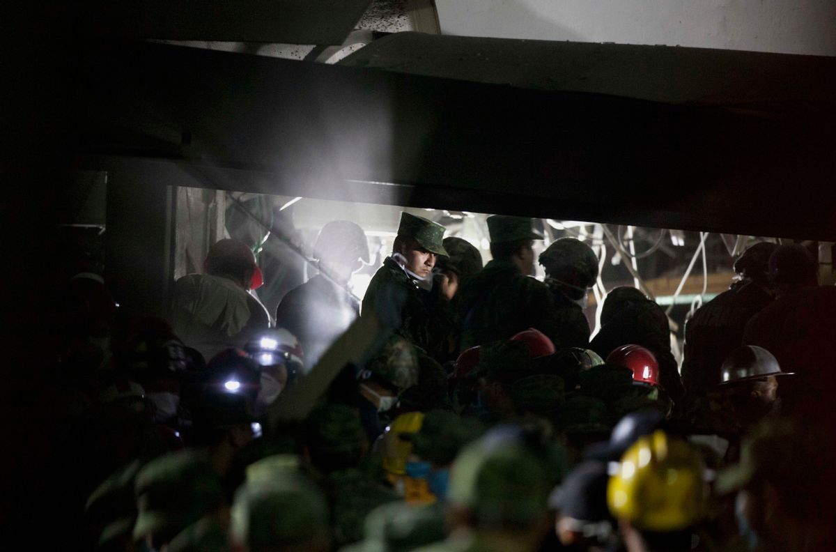 Rescue workers, firefighters and military search for survivors at the site of an explosion in a building at Mexico's state-owned oil company PEMEX complex.   (AP/Eduardo Verdugo)
