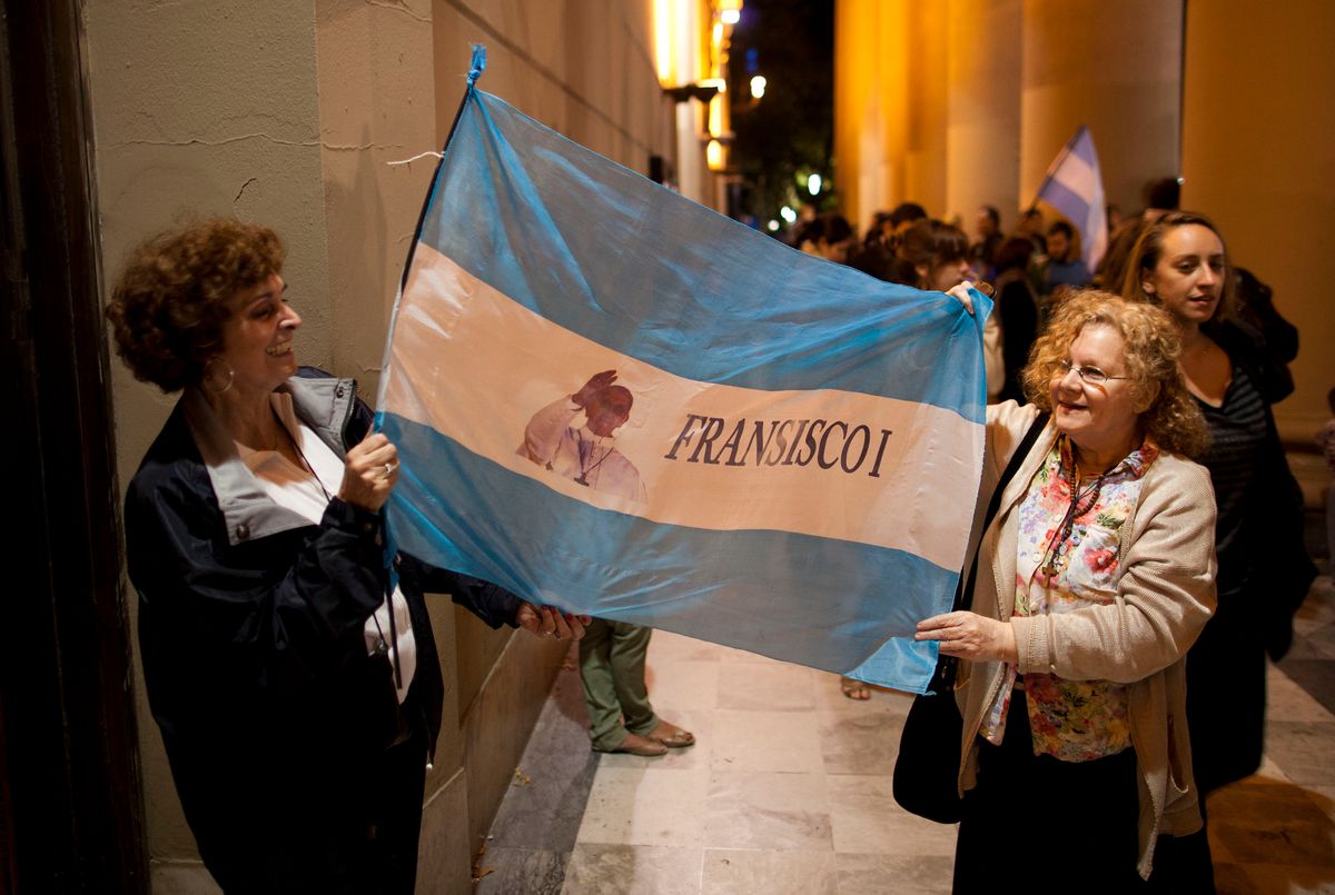 Faithful hold up an Argentine flag with an image of Buenos Aires' Archbishop Jorge Bergoglio that reads in Spanish "Francisco I" outside the Metropolitan Cathedral as people gather in Buenos Aires, Argentina.       (AP/Ivan Fernandez)