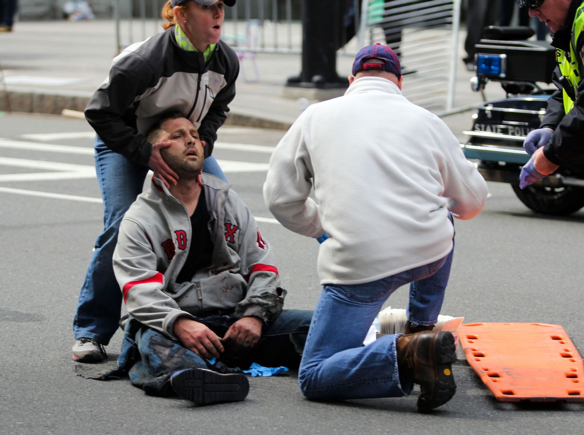 People assist an injured after an explosion at the 2013 Boston Marathon in Boston, Monday, April 15, 2013.       (AP/The Daily Free Press, Kenshin Okubo)