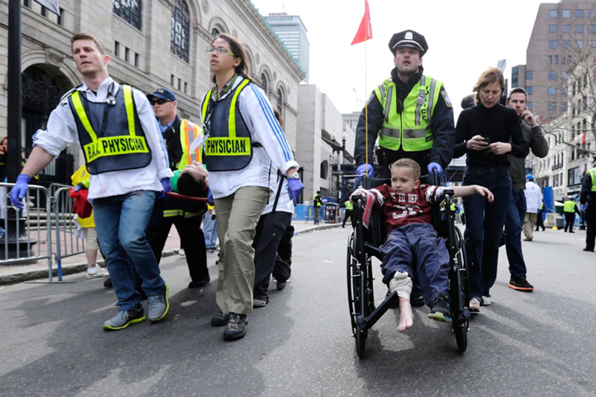 A Boston police officer wheels in injured boy down Boylston Street as medical workers carry an injured runner following an explosion during the 2013 Boston Marathon.  (AP/Charles Krupa)