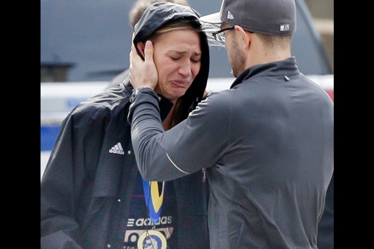 An unidentified Boston Marathon runner is comforted as she cries in the aftermath of two blasts which exploded near the finish line of the Boston Marathon in Boston, Monday, April 15, 2013. (AP/Elise Amendola)