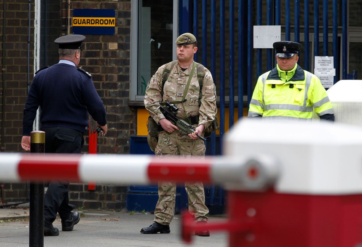 An armed soldier stands guard at the gate of the Royal Artillery Barracks near the scene of a terror attack in Woolwich, southeast London, Thursday, May 23, 2013.   (AP/Sang Tan)