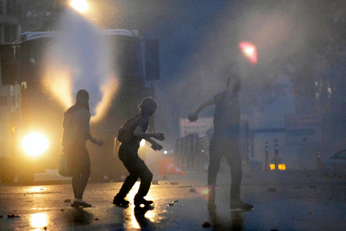 Riot police use tear gas and pressurized water to quash a demonstration by hundreds of people trying to prevent the demolition of trees at an Istanbul park, Turkey, Friday, May 31, 2013. (AP)