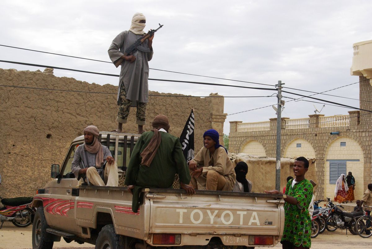 Fighters from Islamist group Ansar Dine stand guard in Timbuktu, Mali, as they prepare to publicly lash a member of the Islamic Police found guilty of adultery.    (Associated Press)