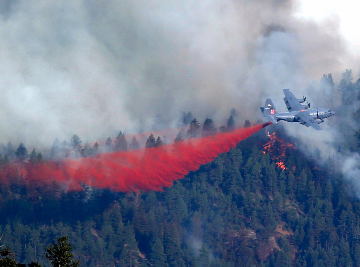 A military C-130 drops a load of fire retardant on a wildfire near Pine, Colo., on Wednesday, June 19, 2013.         (AP/Ed Andrieski)
