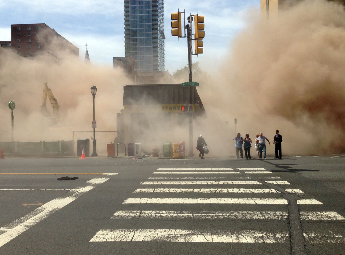 A dust cloud rises as people run from the scene of a building collapse on the edge of downtown Philadelphia on Wednesday, June 5, 2013.  (AP/Jordan McLaughlin)