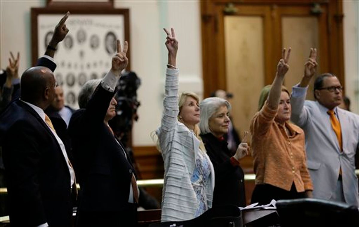 Sen. Wendy Davis, D-Fort Worth, center, who tries to  filibuster an abortion bill, hold up a no vote as time expires, Wednesday, June 26, 2013, in Austin, Texas.                 (AP Photo/Eric Gay)