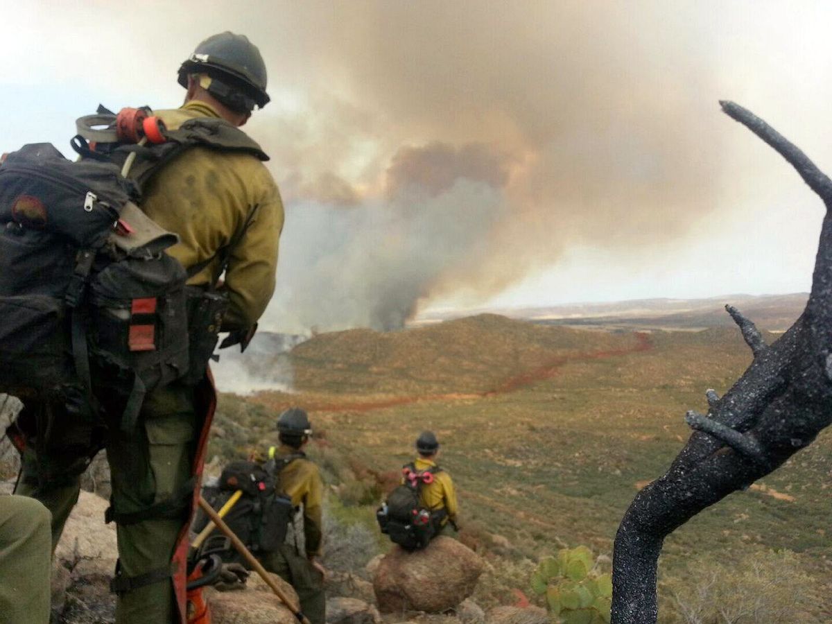 In this photo shot by firefighter Andrew Ashcraft, members of the Granite Mountain Hotshots watch a growing wildfire that later swept over and killed the crew of 19 firefighters near Yarnell, Ariz., Sunday, June 30, 2013.    (AP/Courtesy of Juliann Ashcraft)