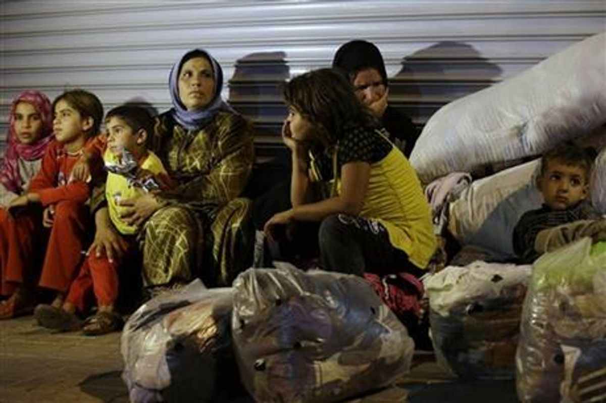 Syrian refugees stand sit in front of a closed shop in Reyhanli, Turkey, Saturday, Aug. 31, 2013. U.S. President Barack Obama said he has decided that the United States should take military action against Syria in response to a deadly chemical weapons attack, but he said he will seek congressional authorization for the use of force.    (AP Photo/Gregorio Borgia)