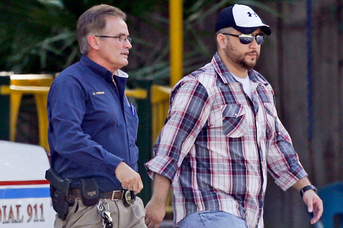 George Zimmerman, right, is escorted by a Lake Mary police officer, Sept. 9, 2013, in Lake Mary, Fla.                      (AP/John Raoux)