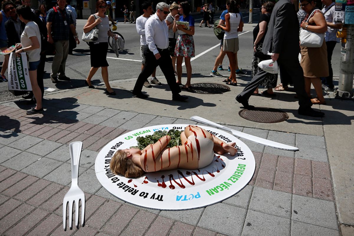 An activist with PETA lies covered with barbecue sauce during a protest against the consumption of animal products, in Ottawa July 17, 2013.    (Reuters/Chris Wattie)