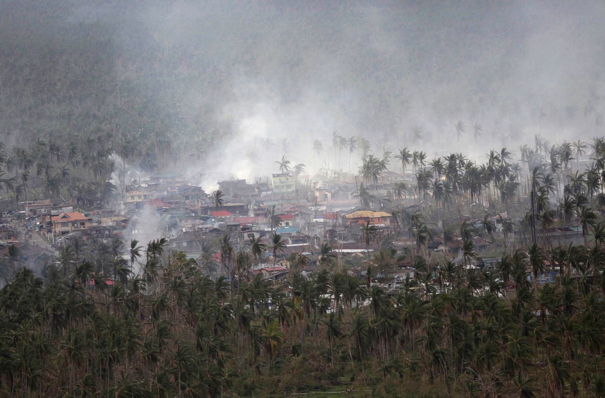 Smoke billows around damaged houses in this aerial shot from a Philippine Air Force helicopter at typhoon-ravaged Leyte province, central Philippines Monday, Nov. 18, 2013. When a newspaper for Filipino workers in New Zealand told readers how to donate to the typhoon relief effort in their homeland, it mentioned agencies like the Red Cross but not a list of government bank accounts that the Philippine Embassy had sent over. (AP Photo/Aaron Favila)  (AP/Aaron Favila)