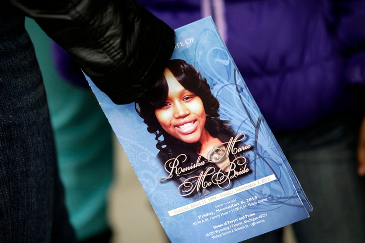 A mourner holds an obituary displaying a picture of shooting victim Renisha McBride during her funeral service in Detroit, November 8, 2013.       (Reuters/Joshua Lott)