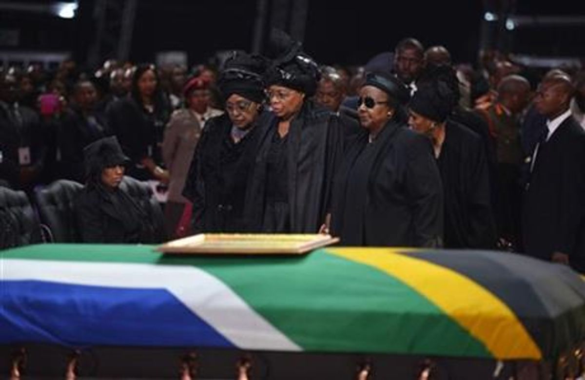 Winnie Madikizela-Mandela, left, Nelson Mandela's former wife, left and Nelson Mandela’s widow Graca Machel stand over the former South African president's casket during his funeral service in Qunu, South Africa, Sunday.  (AP)