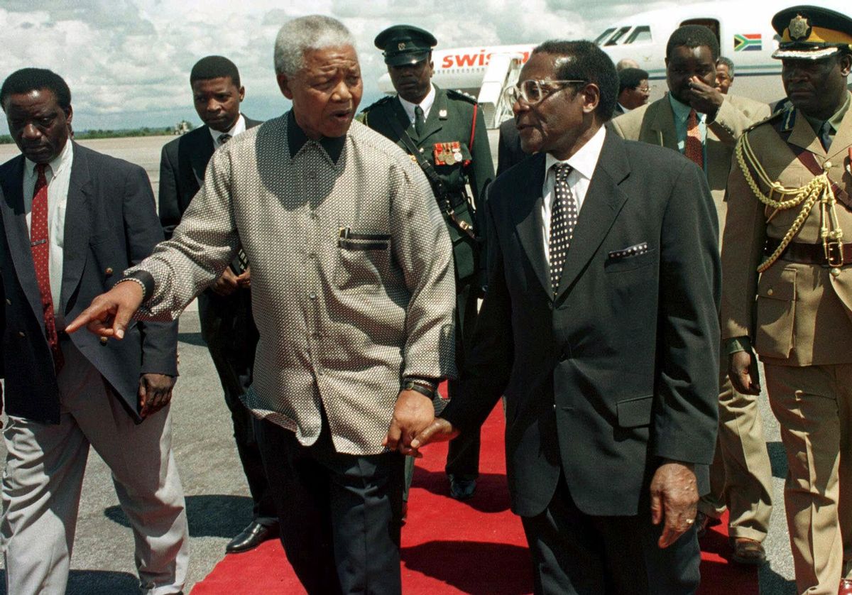 This Sunday Dec. 13, 1998 file photo shows former South African president Nelson Mandela, left, with Zimbabwean President Robert Mugabe in Harare.    (AP/Rob Cooper)