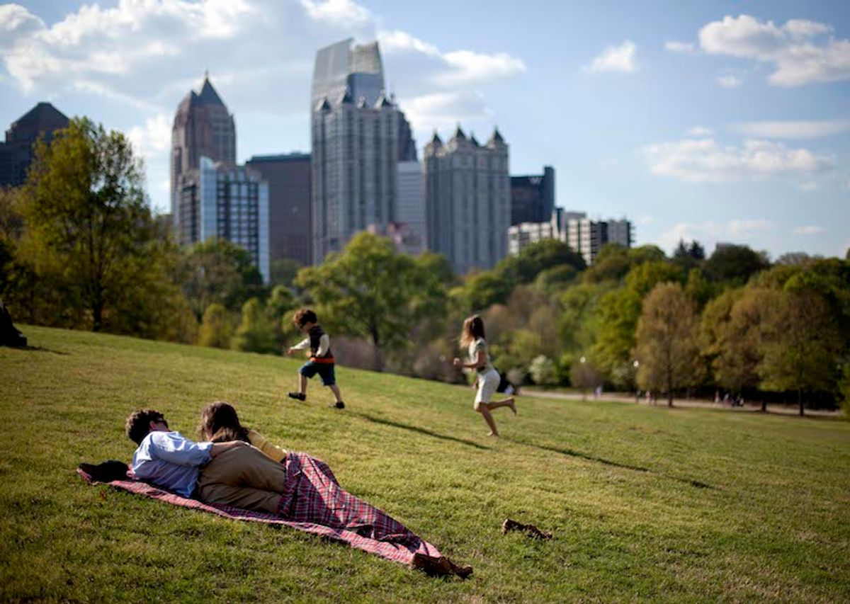 A couple enjoys a sunny afternoon against the backdrop of the Midtown skyline from Piedmont Park in Atlanta.   (David Goldman/AP)