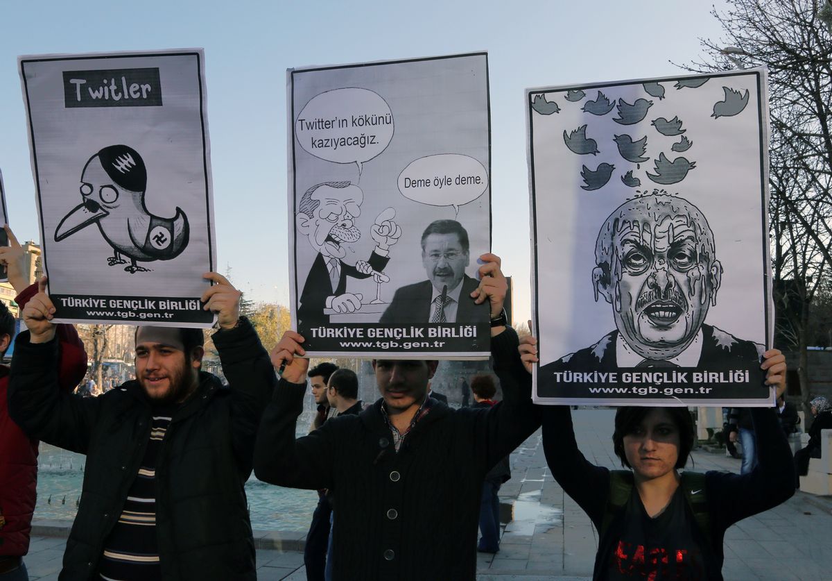 Members of the Turkish Youth Union hold cartoons depicting Turkey's Prime Minister Recep Tayyip Erdogan during a protest against a ban on Twitter, in Ankara, Turkey, Friday, March 21, 2014. Turkey's attempt to block access to Twitter appeared to backfire on Friday with many tech-savvy users circumventing the ban and suspicions growing that the prime minister was using court orders to suppress corruption allegations against him and his government. Cartoon in center reads: Erdogan, left, to his Ankara Mayor Melih Gokcek " we will rip out the roots of Twitter." Gokcek: "don't say it." (AP Photo/Burhan Ozbilici)     (AP)