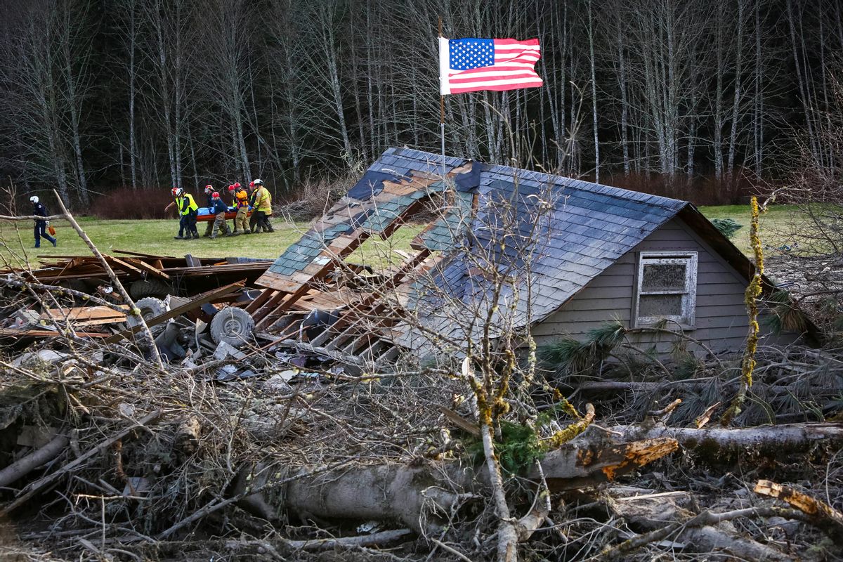 Rescue workers remove a body from the wreckage of homes destroyed by a mudslide near Oso, Wash, Monday, March 24, 2014. (AP Photo/seattlepi.com, Joshua Trujillo)   