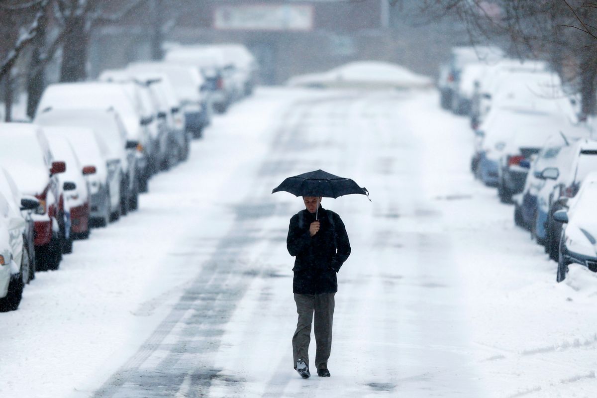 A morning commuter walks to a train station during a winter snowstorm Monday, March 3, 2014, in Philadelphia. Spring is in sight, but winter kept its icy hold on much of the country Monday, with up to a foot of snow and plummeting temperatures expected across the Mid-Atlantic states and up the East Coast. (AP Photo/Matt Rourke) 