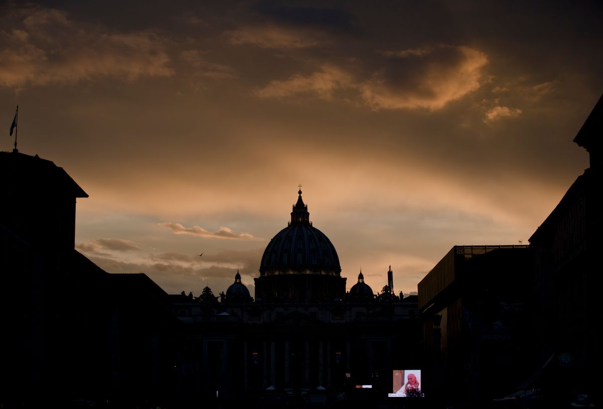A large screen for public display shows Pope John Paul II after sunset outside St. Peter's Square at the Vatican, Saturday, April 26, 2014.  (AP Photo/Vadim Ghirda)