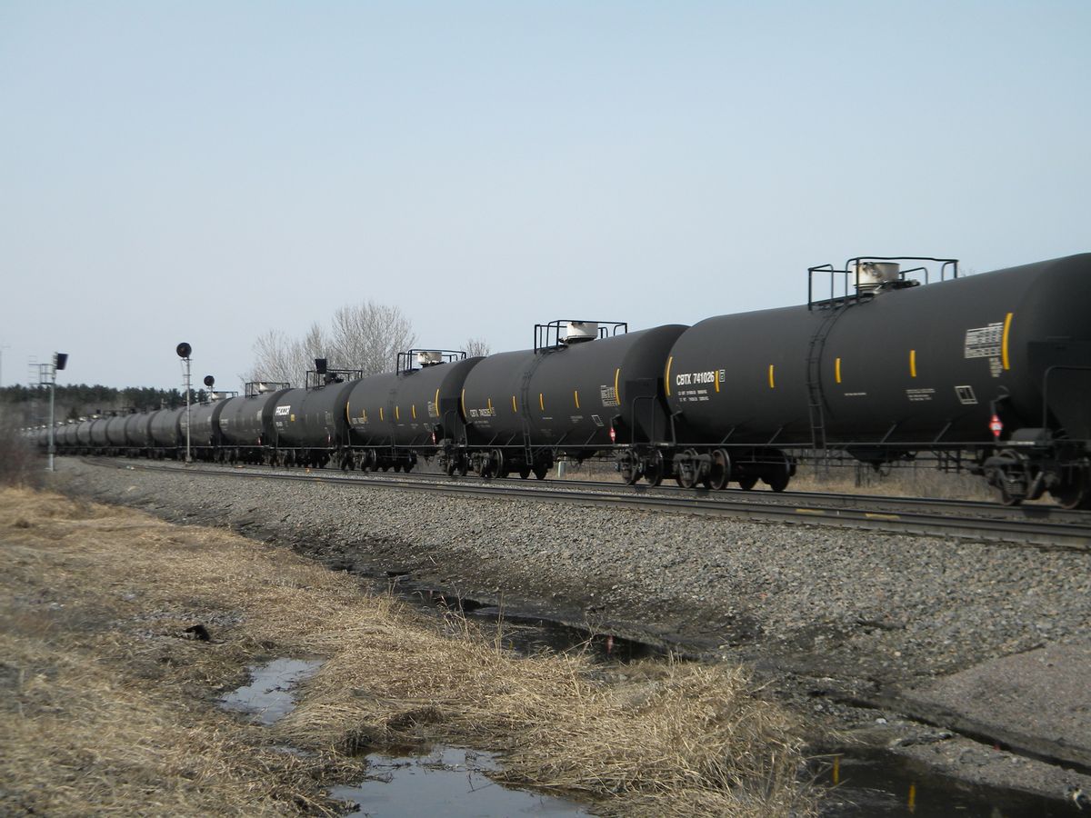 An oil-tank train operated by Burlington Northern Santa Fe Corp., based in Fort Worth, Texas, cruises east alongside U.S. 10, a few miles outside of Staples, Minn.     (AP/Mike Cronin)