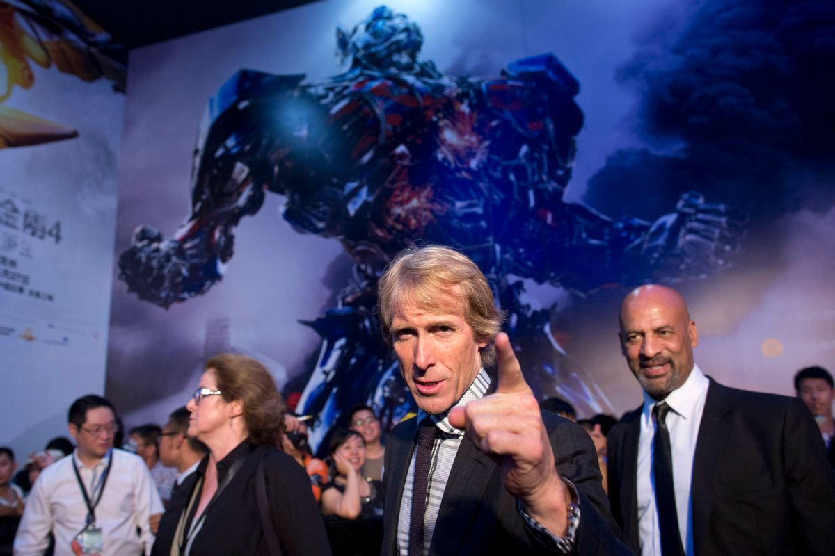 In this Monday June 23, 2014 photo, director Michael Bay, center, gestures to fans as he attends the premiere of movie "Transformers: Age of Extinction" at a theatre in Beijing, China. As box-office revenue growth flattens out at home, Hollywood studios are adding Chinese elements to their films to appeal to China, already the world's second biggest movie market with $3.6 billion in ticket sales last year and where studios reap much less money from merchandising and DVD sales. (AP Photo/Alexander F. Yuan) (Alexander F. Yuan)