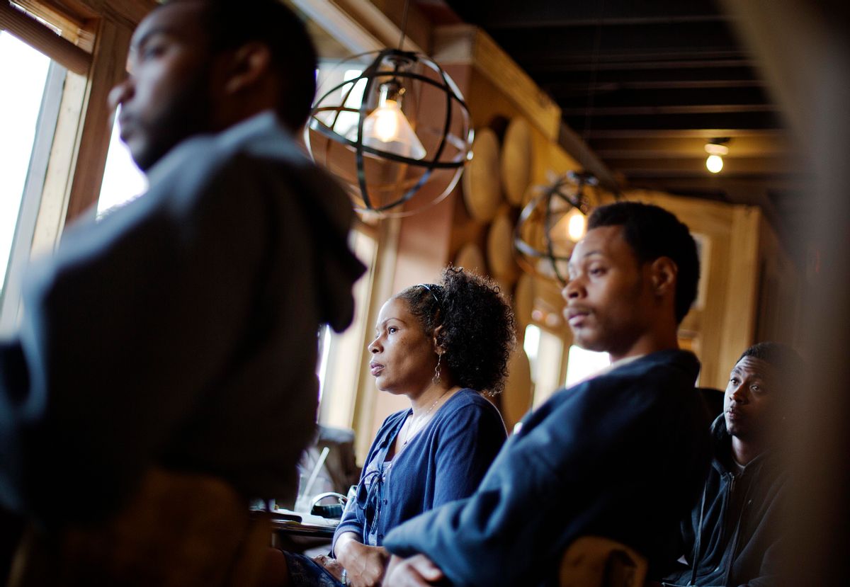 In this photo taken May 18, 2014, Lisa Marie Hyman-Walker, center, and son Eugene Mosby, right, listen to Leo Smith (not shown), minority engagement director for the Georgia Republican Party, speaking at the Delightful Eatz Bar and Grill in the historically African American neighborhood of Edgewood in Atlanta. Smith is on the GOP's front lines recruiting African-American voters in pivotal states. (AP Photo/David Goldman)  (AP)