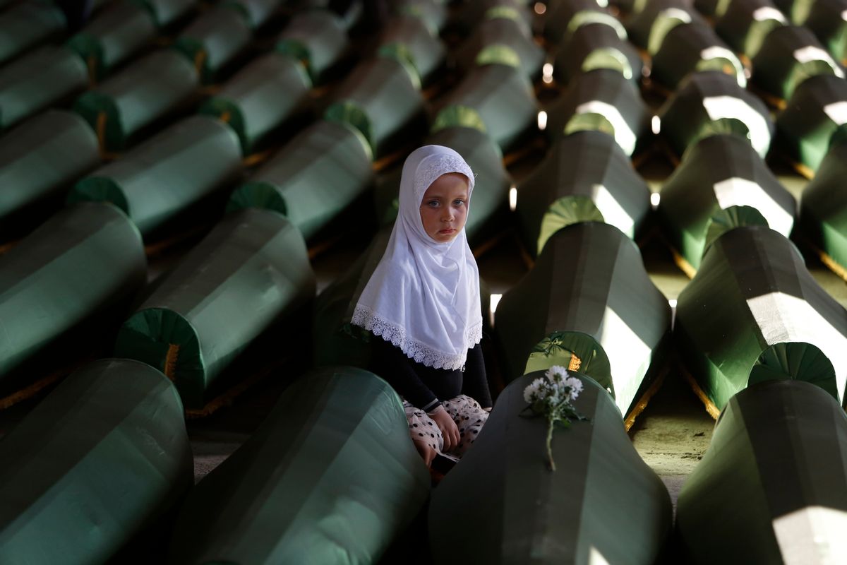 AP10ThingsToSee - Ema Hasanovic, 5, a young Bosnian Muslim girl, pays her respects near to the coffin of her uncle, in the Memorial center in Potocari, 200 km northeast of Sarajevo, Bosnia, Wednesday, July 9, 2014. Hundreds of people turned out to pay their respects to 175 victims of the Srebrenica massacre. The remains of the men and boys, found in mass graves and identified through DNA analysis, will be buried in Srebrenica during the 19th anniversary of the massacre on Friday. (AP Photo/Amel Emric) (AP)