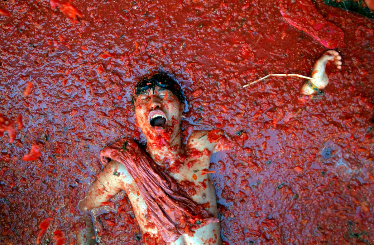 AP10ThingsToSee- A man lies in a puddle of squashed tomatoes, during the annual "tomatina" tomato fight fiesta in the village of Bunol, 50 kilometers outside Valencia, Spain, Wednesday, Aug. 27, 2014. (AP Photo/Alberto Saiz) (AP)