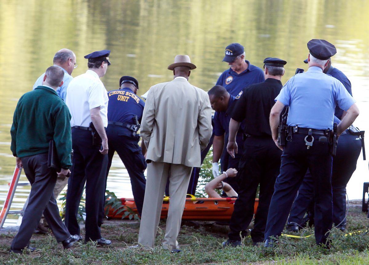Philadelphia police and other law enforcement officials view a body pulled from the Schuylkill River in Fairmount Park in Philadelphia, Wednesday, Aug. 27, 2014.  The bound bodies of two people were found in the river Wednesday, and a third man who said he managed to free himself is being treated at a hospital for stab wounds, police said. (AP Photo/Jacqueline Larma) (AP)