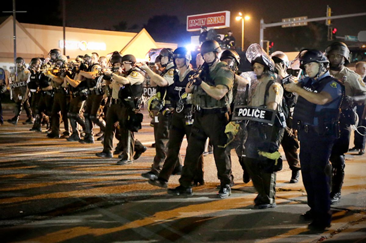 Police advance to clear people, Aug. 18, 2014, during a protest in Ferguson, Mo.              (AP/Charlie Riedel)